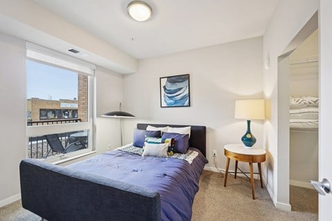 A bedroom with a large bed and a view of a balcony.