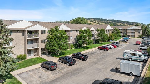 an aerial view of an apartment complex with cars parked in a parking lot