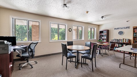 a classroom with tables and chairs and a library