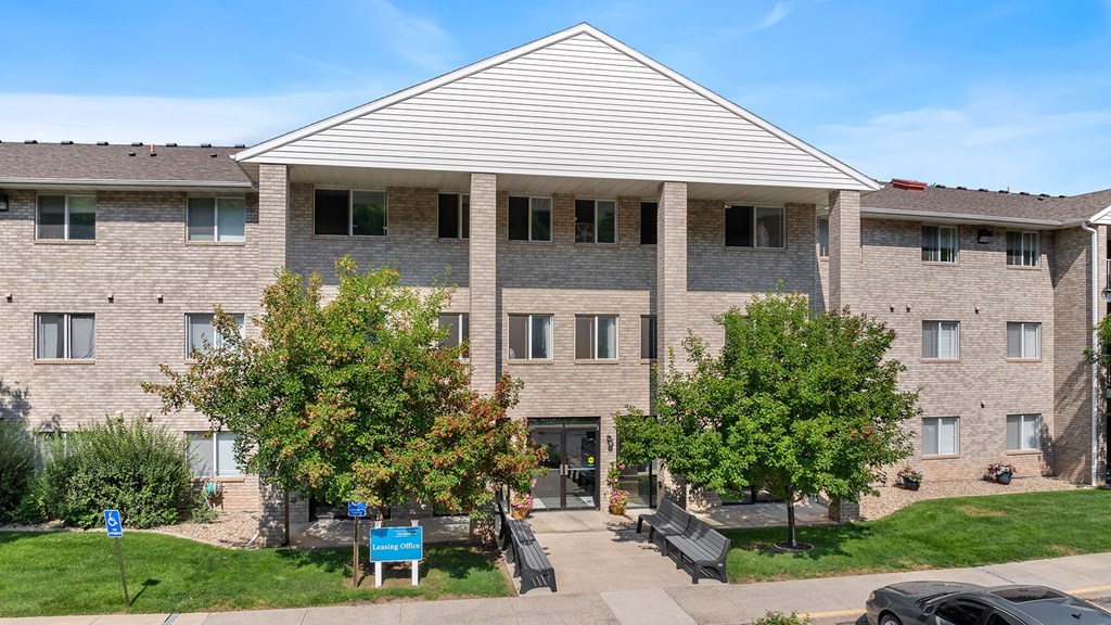 a brick apartment building with trees in front of it
