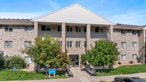 a brick apartment building with trees in front of it
