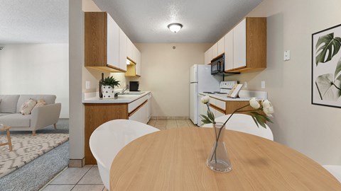 a dining room table with a vase of flowers and a kitchen and living room