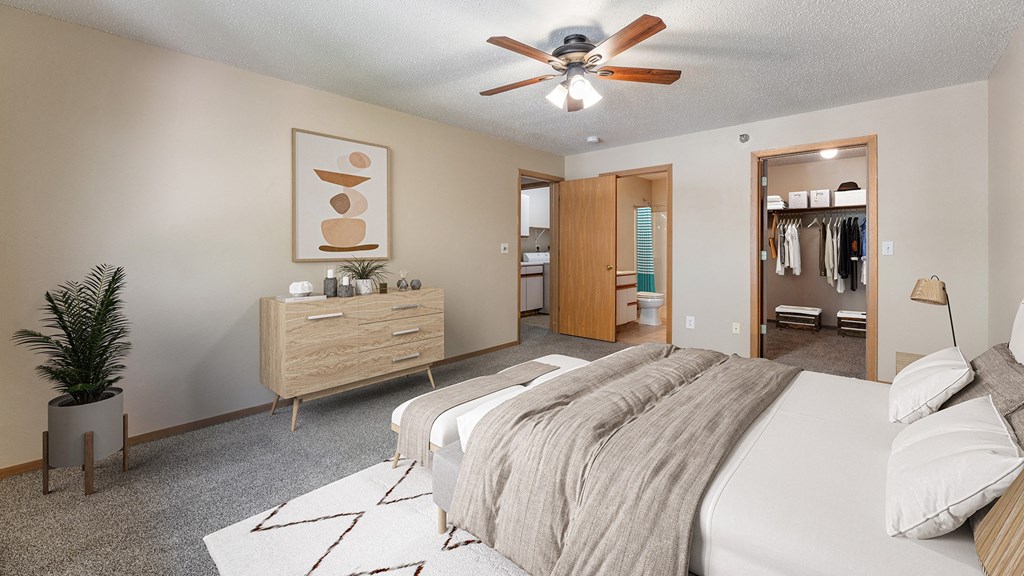 a bedroom with a large bed and a ceiling fan