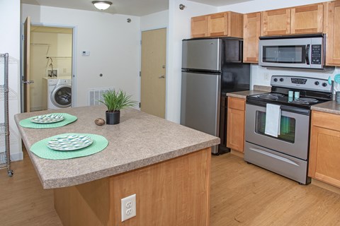 a kitchen with stainless steel appliances and an island with a granite counter top