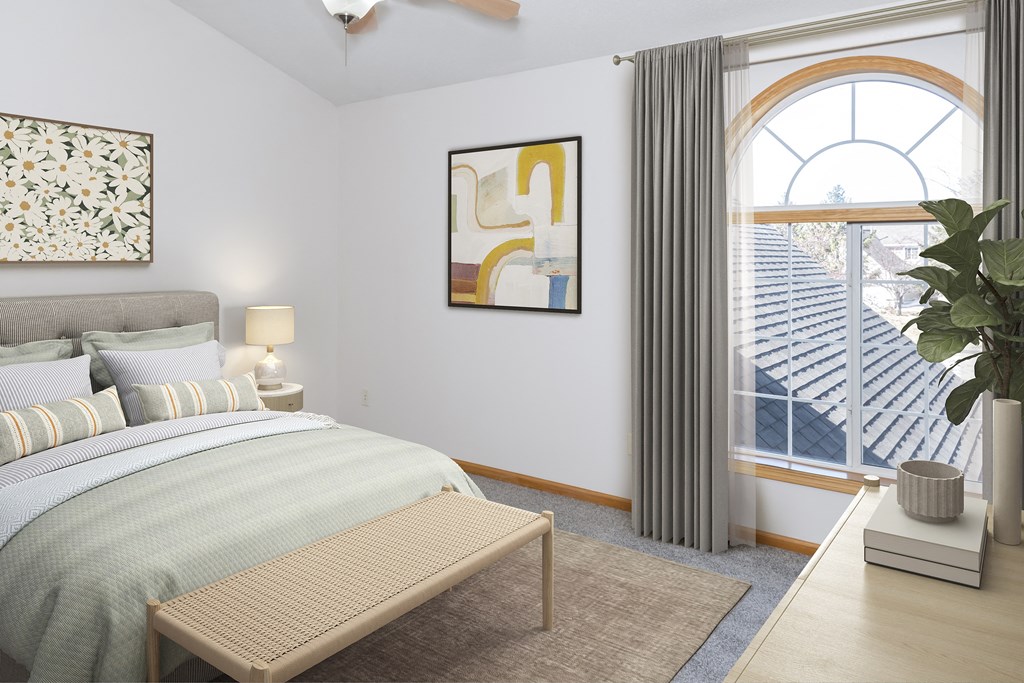 a bedroom with a large window and a bench at the end of the bed