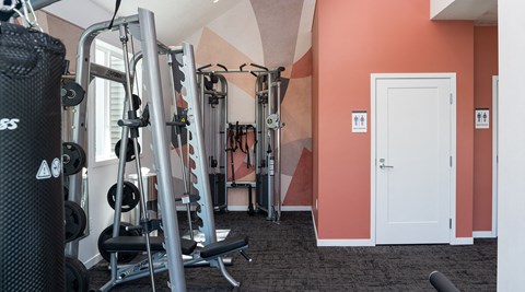 a gym with various exercise equipment in a room with a door