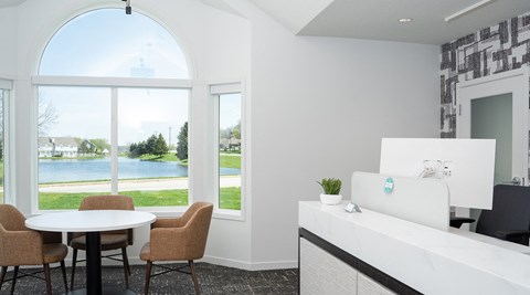 a living room with a view of a lake and a table and chairs