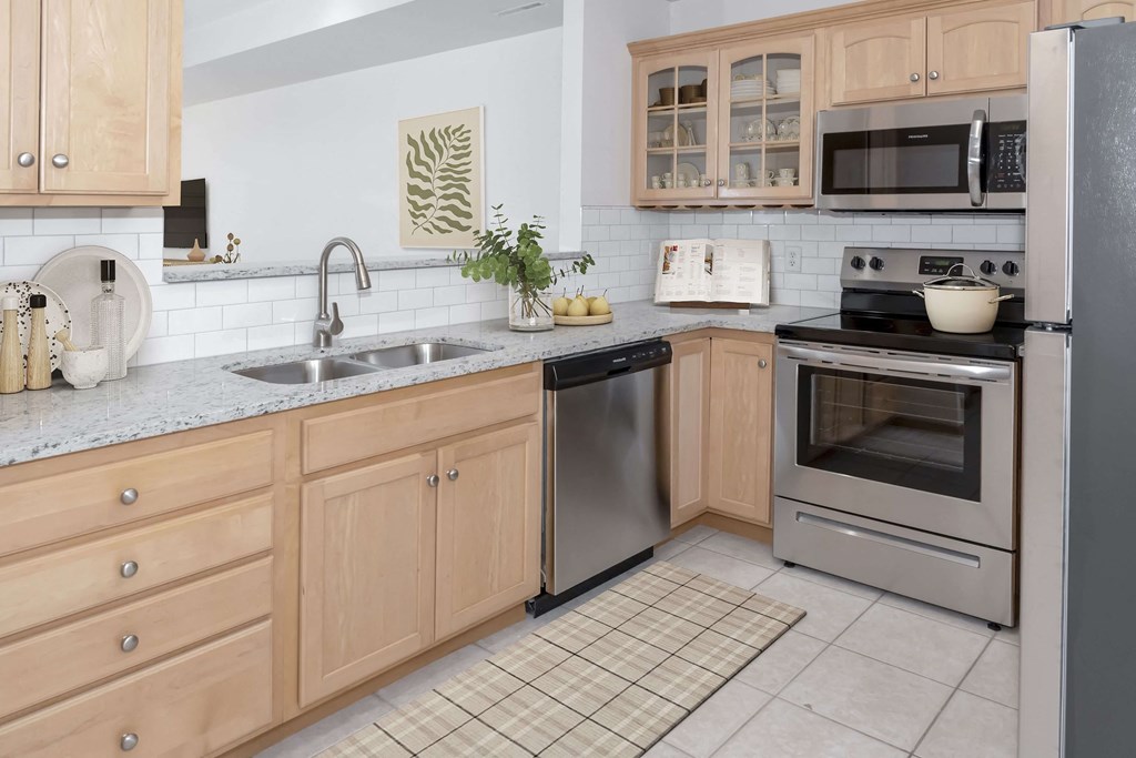 a kitchen with wooden cabinets and stainless steel appliances