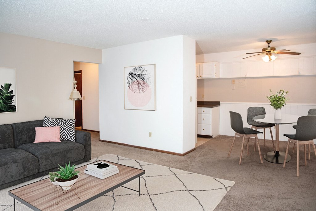 a living room with a couch a table and a ceiling fan