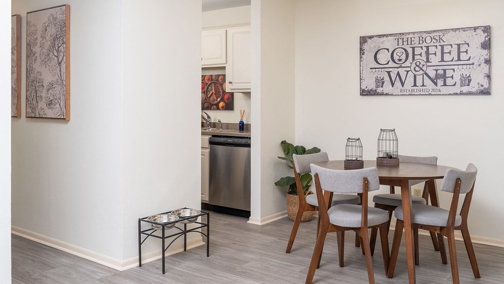a dining room with a table and chairs and a sign that reads coffee and wine a dining room with a table and chairs and a sign that reads coffee and wine at The Bosk Apartment Homes, Minnesota