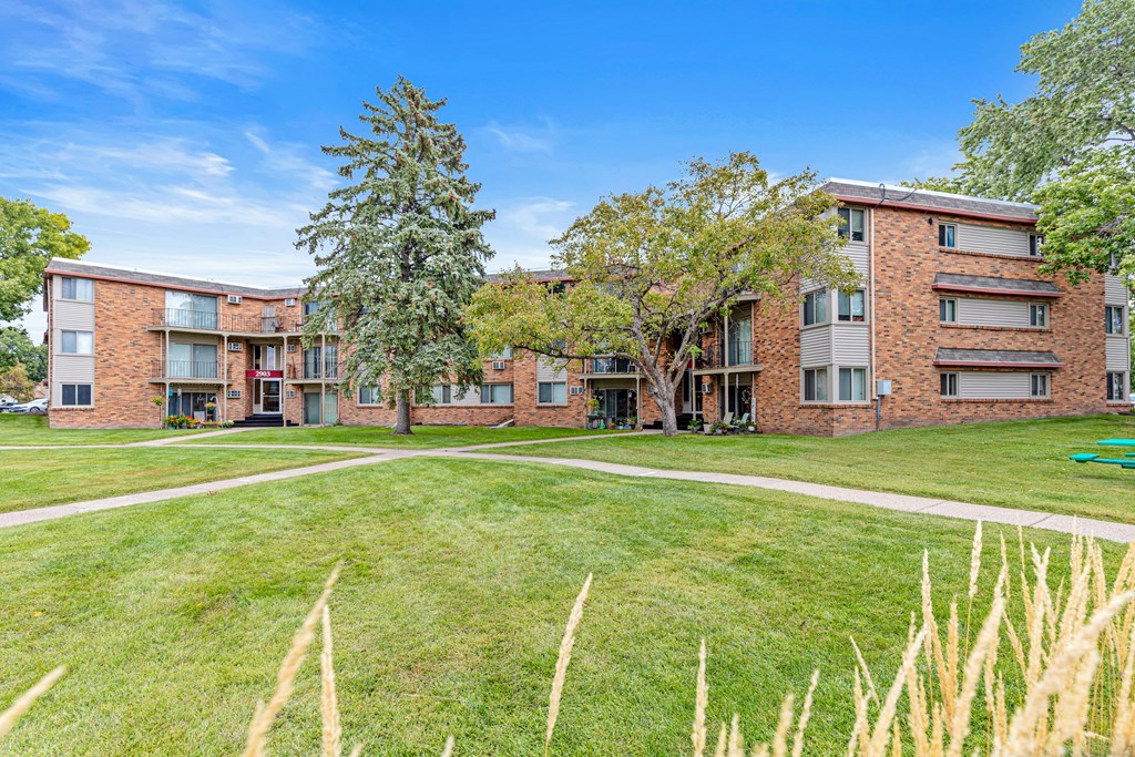 A grassy area in front of apartment buildings.