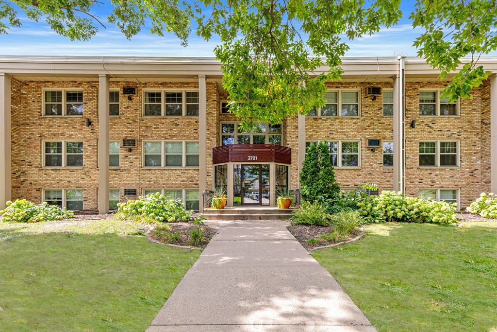A building with a red awning and a walkway leading to it.