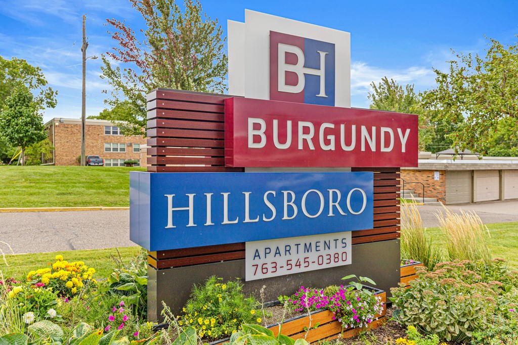A sign for Burgundy Hillsboro Apartments with a phone number on it.