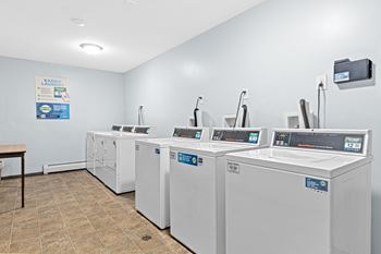 A laundromat with a row of washers and dryers.