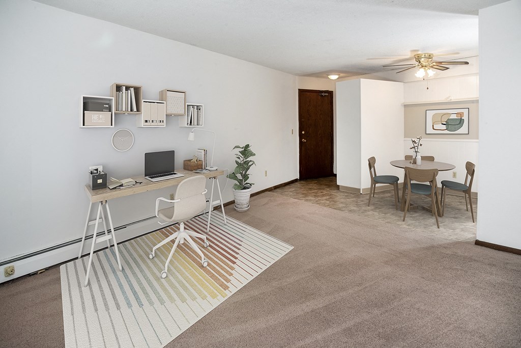 an open living room with a desk and a dining room table