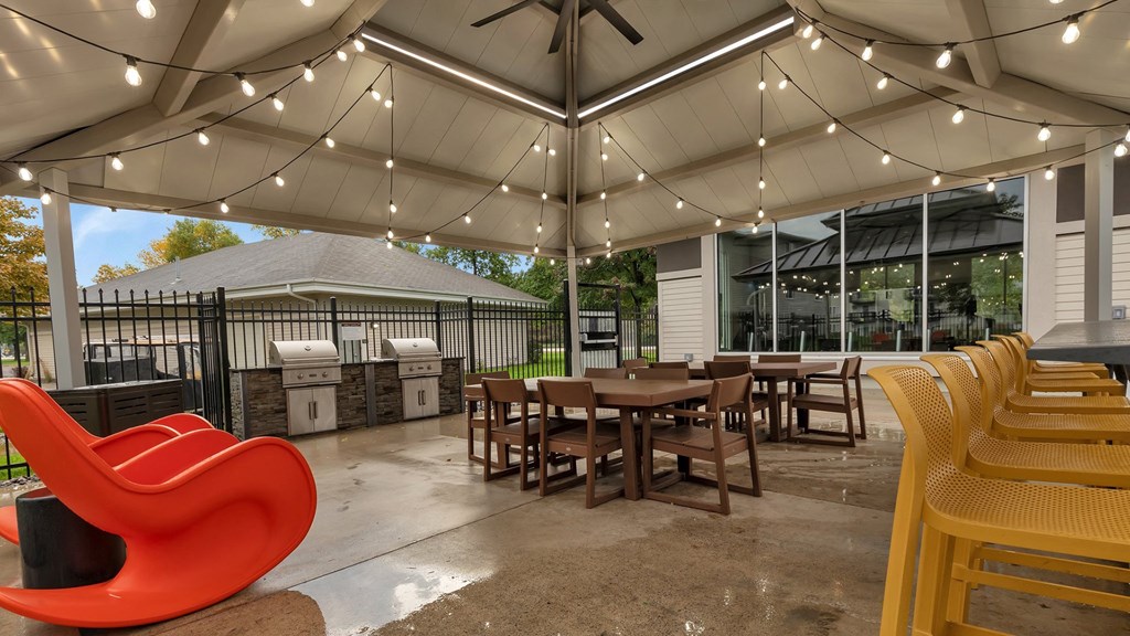 a patio with tables and chairs and a grill