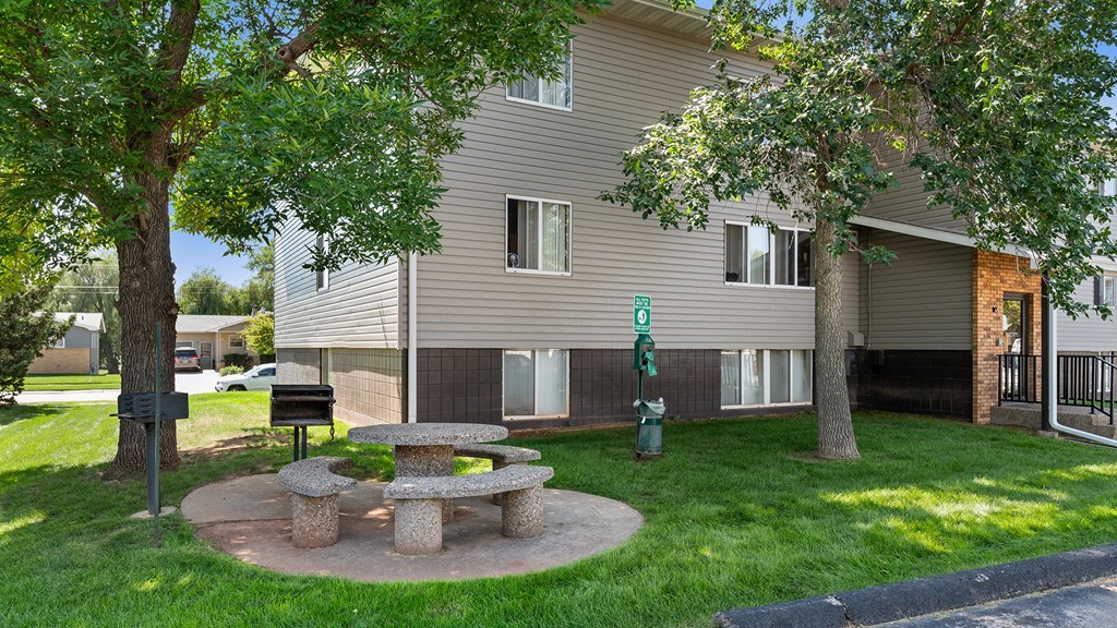 a stone picnic table in the yard of an apartment building