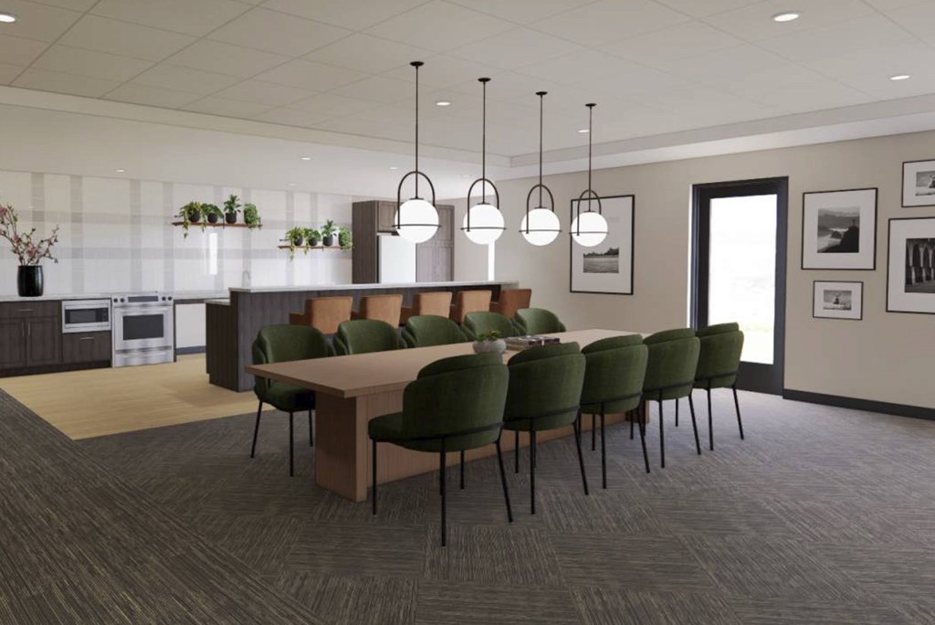 A conference room with a long table surrounded by green chairs.