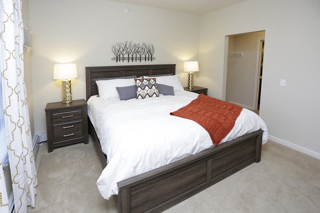 a bedroom with a bed and two nightstands and a closet