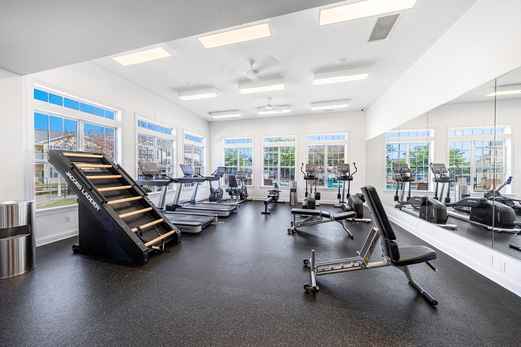 A gym with treadmills, exercise bikes, and other equipment.