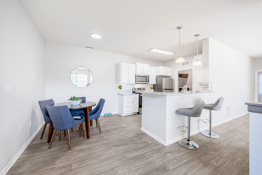 A kitchen with a white island and bar stools.
