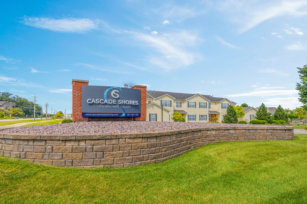 A sign for Cascade Shores Apartments is in front of a building.