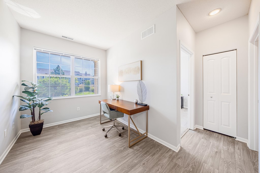 A room with a desk and a chair in it.