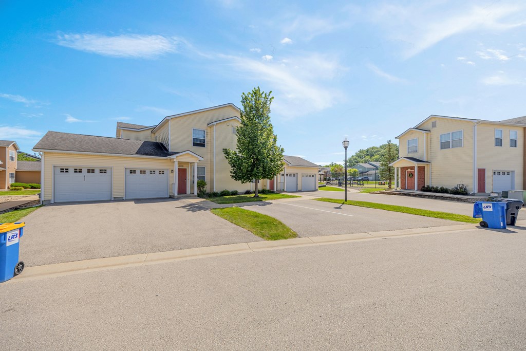 A residential area with houses and a tree in the foreground.