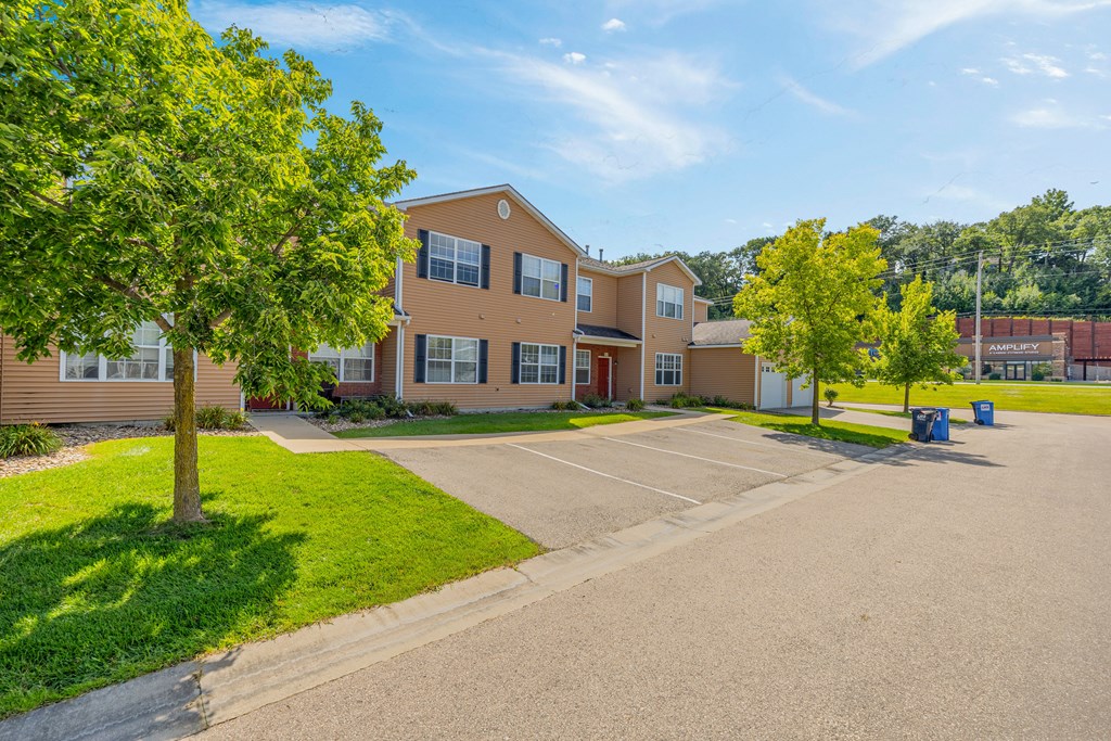 A large building with a parking lot in front.
