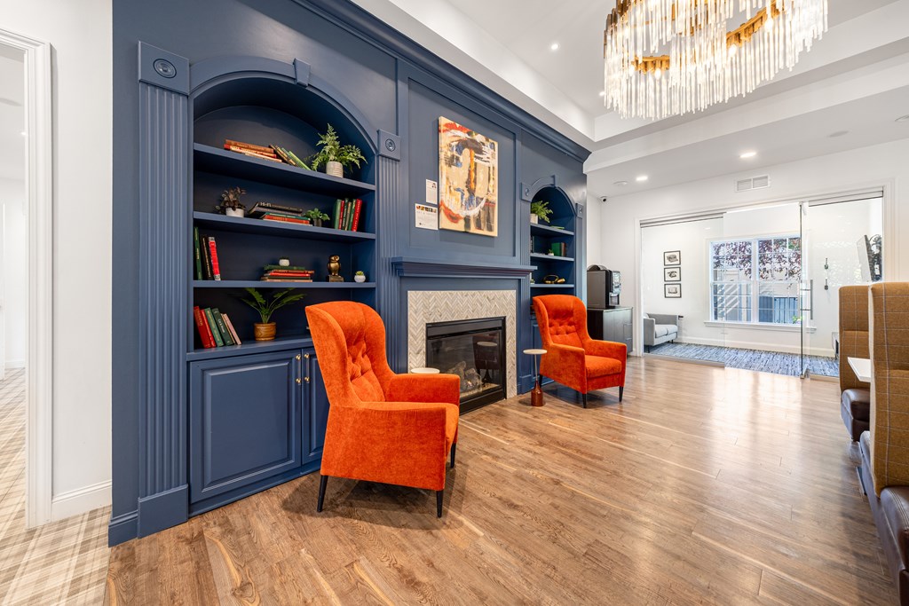 A living room with a fireplace and two orange chairs.