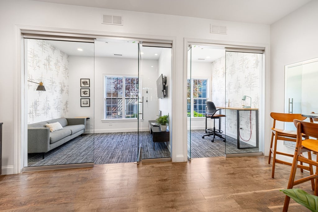 A living room with a grey couch and a wooden chair.