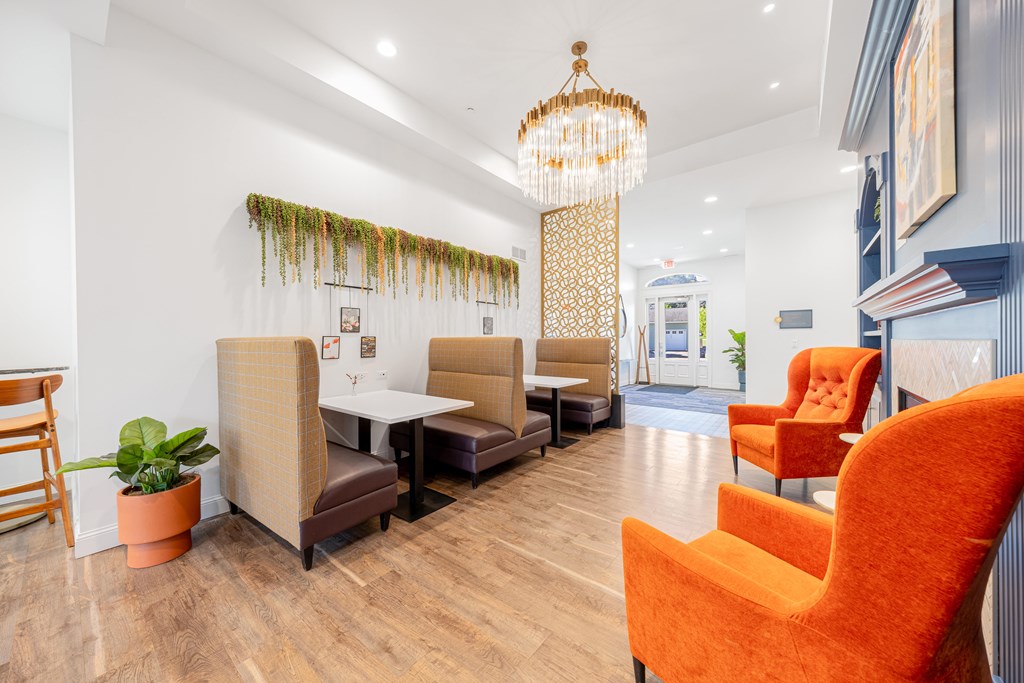A room with orange chairs and a wooden table.