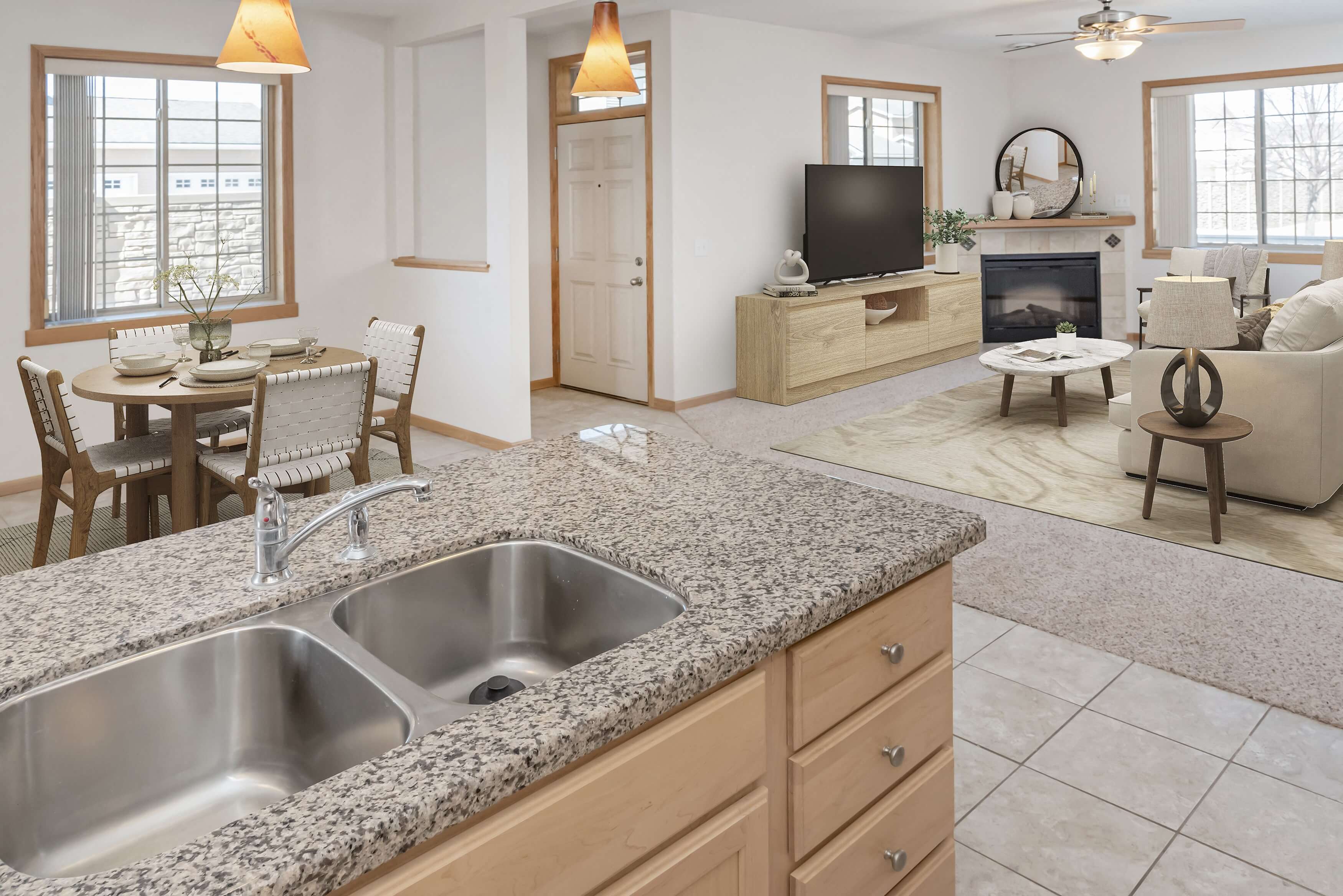 a kitchen with a sink and a tv in a living room