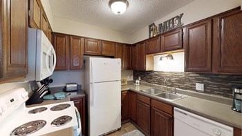 Dark wood cabinetry in an updated kitchen with tile backsplash. Sign above kitchen sink window reads "Family." - Photo Gallery 2