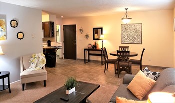 Inviting and spacious living room looks into the separate dining space lit by a pendant light. - Photo Gallery 3