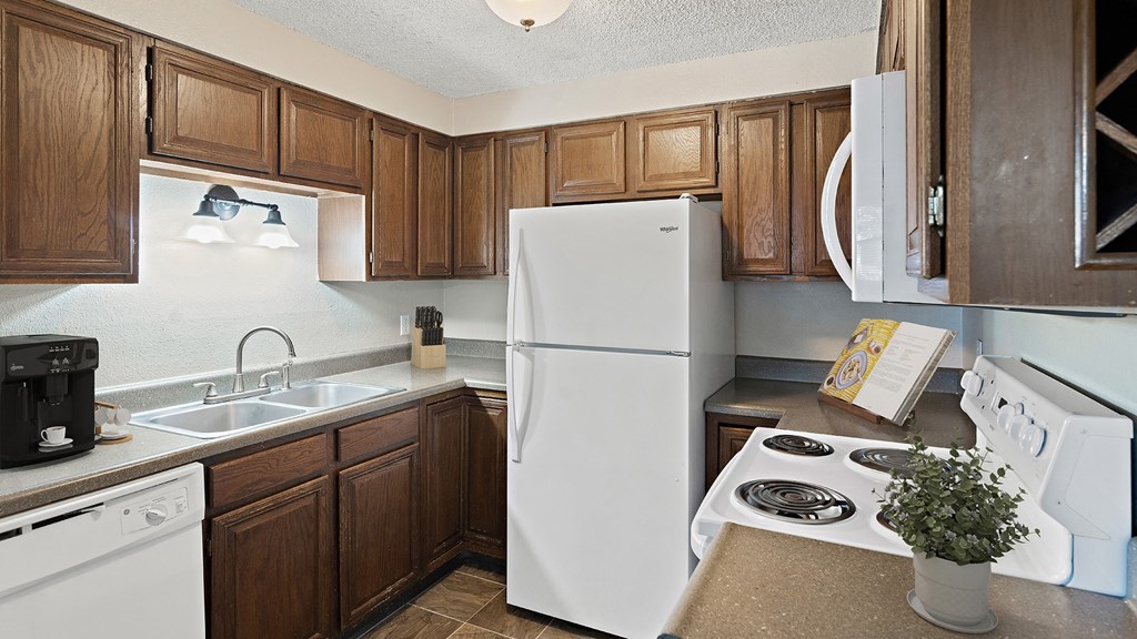 a kitchen with white appliances and wooden cabinets