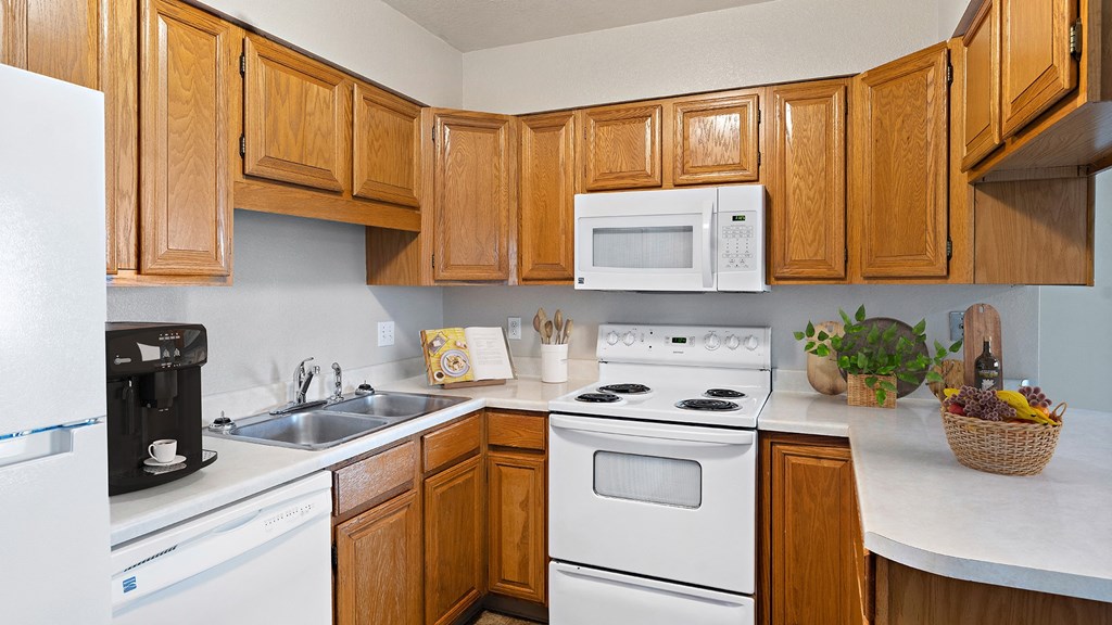 a kitchen with white appliances and wooden cabinets