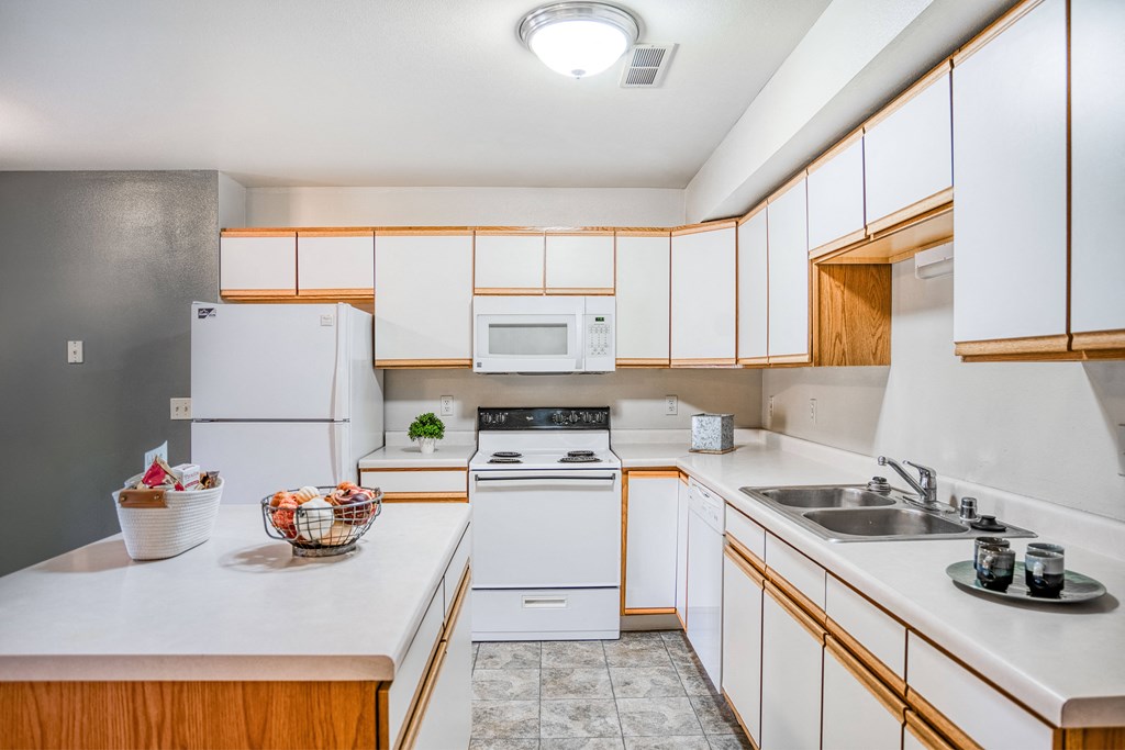 a kitchen with white appliances and wooden cabinets
