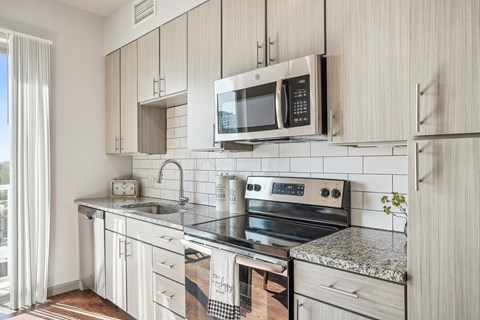 an updated kitchen with stainless steel appliances and white cabinets