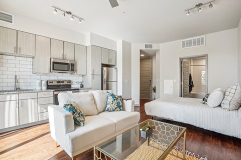 a living room and kitchen with a couch and a table