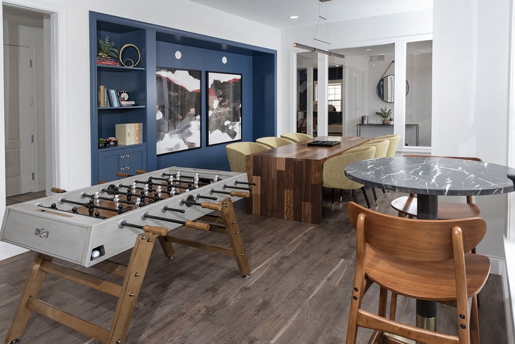 a recreation room with a foosball table and a dining table and chairs