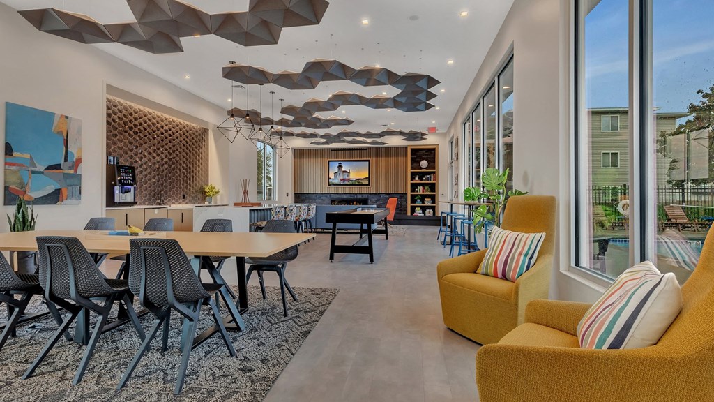 the lobby of a building with tables and chairs and large windows