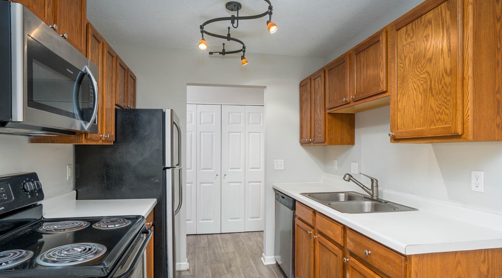 a kitchen with wood cabinets and white countertops
