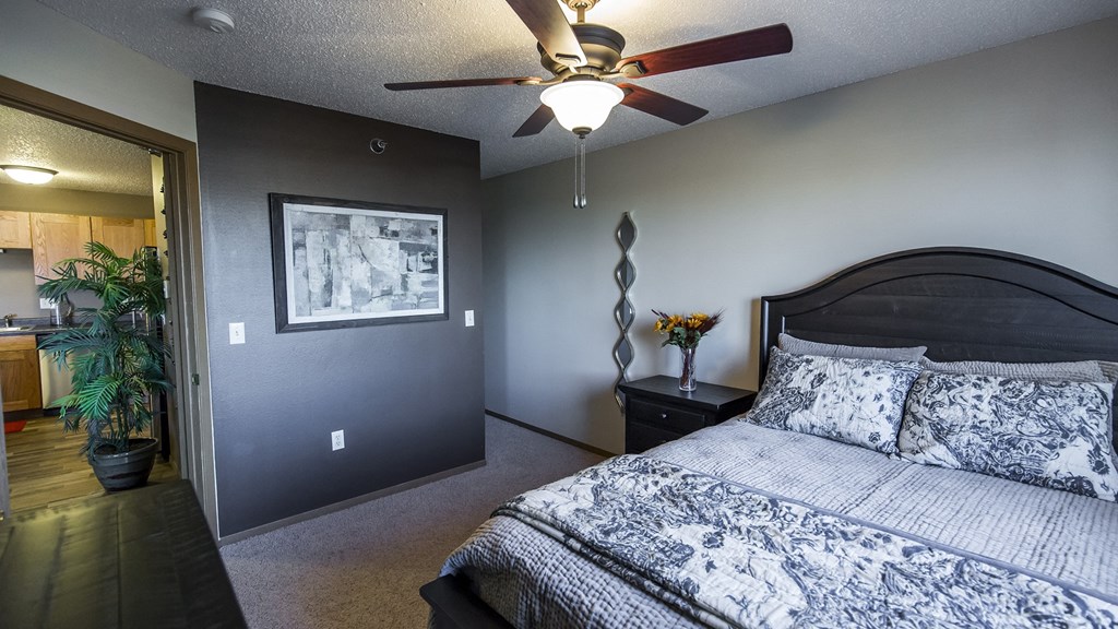 the master bedroom has a large bed and a ceiling fan