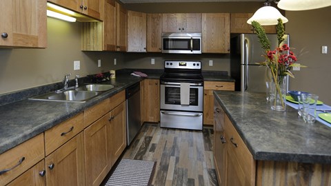 a kitchen with wooden cabinets and stainless steel appliances