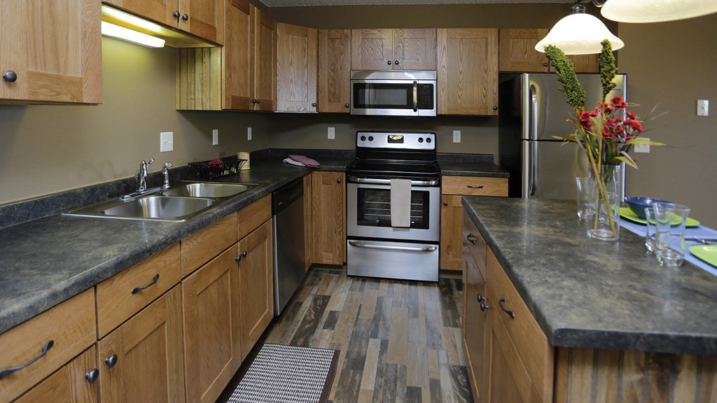 a kitchen with wooden cabinets and stainless steel appliances