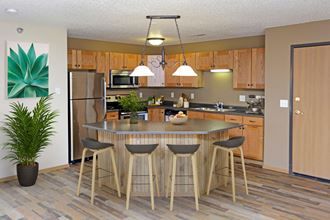 Open kitchen layout with stainless steel appliances, spacious island, and laminate countertops.