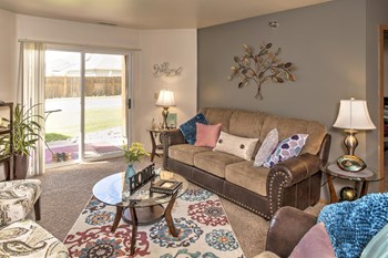Comfortable and spacious living room with natural light from the doors leading out to the patio or balcony. - Photo Gallery 2