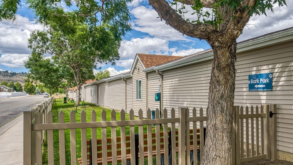 a row of houses with a fence and a tree