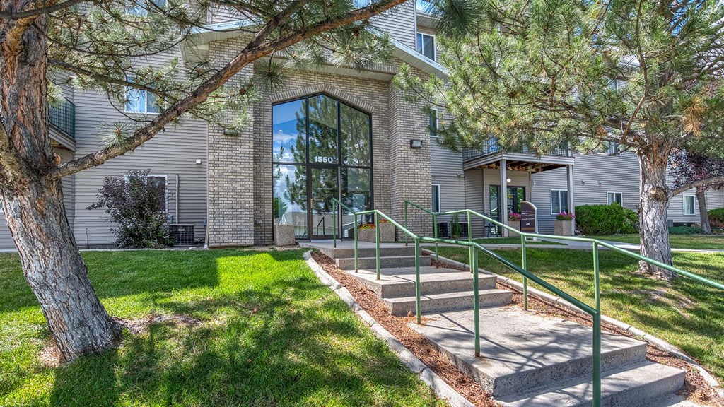 the front of a house with stairs and a tree